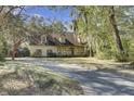 Traditional home featuring a welcoming front porch and a driveway, nestled among mature trees and green spaces at 1042 Chambers Ln, Mount Pleasant, SC 29464