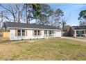 Well-maintained one-story home featuring shutters, a front porch, and an attached garage on a verdant lot at 105 Gippy Dr, Summerville, SC 29486