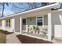 Inviting front porch features outdoor seating, fresh plants, and a decorative wreath on the front door at 105 Gippy Dr, Summerville, SC 29486