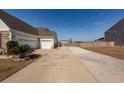 Long driveway leading to a spacious two-car garage, and a landscaped yard at 121 Lakelyn Rd, Moncks Corner, SC 29461