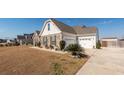 Attractive house showcasing stone accents, a well-manicured lawn, and an attached two-car garage at 121 Lakelyn Rd, Moncks Corner, SC 29461