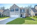 Well-kept two-story home with a two-car garage, manicured lawn, and stylish gray exterior at 1305 Discovery Dr, Ladson, SC 29456