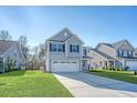 Lovely two-story home with a convenient two-car garage, lush green lawn, and appealing gray exterior at 1305 Discovery Dr, Ladson, SC 29456