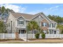 Charming two-story home with a white picket fence, manicured landscaping, and a welcoming front porch at 1588 Grey Marsh Rd, Mount Pleasant, SC 29466