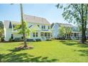 Expansive backyard with lush green grass, mature trees, and an elegant screened porch at 1796 Bolden Dr, Mount Pleasant, SC 29466