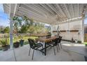 Inviting covered patio with a dining table, chairs, and a view of the backyard at 240 Gazania Way, Charleston, SC 29414
