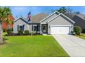 Traditional-style home featuring gray siding, an attached garage, and a lush green lawn at 240 Gazania Way, Charleston, SC 29414