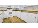 Bright kitchen with wood countertops, white cabinets, and appliances on wood-look vinyl flooring at 2710 Laroche St, Edisto Beach, SC 29438