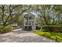 Lovely two-story home with an intricate design, well-maintained landscaping, and spacious driveway at 2863 Jasper Blvd, Sullivans Island, SC 29482