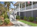 Side view of house with stairs to enter porch, along with green grass and landscaping at 2928 Baywood Dr, Seabrook Island, SC 29455