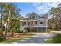 Beautiful gray two-story home with a covered porch and well-manicured lawn at 2928 Baywood Dr, Seabrook Island, SC 29455
