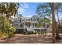 Charming gray home with a welcoming front porch and lush, green landscaping at 2928 Baywood Dr, Seabrook Island, SC 29455