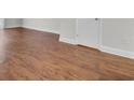 Close-up of new hardwood style flooring with white trim and baseboards at 402 Andrea Ln, Hanahan, SC 29410