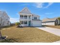 Inviting two-story home with a double porch, attached garage and a lush green lawn perfect for outdoor activities at 415 Ribiero Dr, Summerville, SC 29486