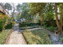 Secluded backyard garden featuring brick pathways, manicured ivy, and mature trees for serene outdoor living at 42 Barre St, Charleston, SC 29401