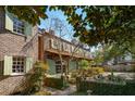 Charming brick home with green shutters, a well-manicured garden, and mature trees for added privacy at 42 Barre St, Charleston, SC 29401