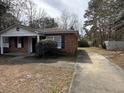 Exterior view featuring a single-story brick home with a driveway and partially visible fenced backyard at 4451 Donwood Dr, Ladson, SC 29456