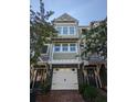 Lovely townhome exterior with a white garage door and green siding framed by blooming trees at 5911 Steward St # 7, Hanahan, SC 29410