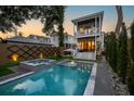 Relaxing backyard oasis featuring a modern pool, spa, privacy fence, and lush landscaping at 71 Moultrie St, Charleston, SC 29403