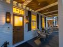 Inviting porch with comfortable seating and stylish lighting fixtures at twilight at 71 Moultrie St, Charleston, SC 29403