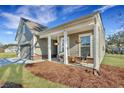Charming home with a covered porch and rocking chairs, perfect for relaxing outdoors at 1028 Island Preserve Rd, Johns Island, SC 29455