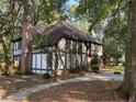 Charming Tudor-style home with a well-manicured front yard and mature trees at 104 Legend Oaks Way, Summerville, SC 29485
