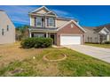 Two-story home featuring a brick facade, attached two-car garage, and well-maintained lawn on a sunny day at 104 Mayfield Dr, Goose Creek, SC 29445