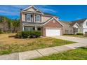 Two-story home featuring a brick facade, attached two-car garage, and well-maintained lawn on a sunny day at 104 Mayfield Dr, Goose Creek, SC 29445