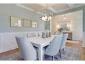 Elegant dining room features modern chandelier, coffered ceilings, stylish wainscotting, and neutral decor at 110 Crosscut Ln, Summerville, SC 29486
