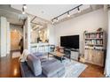Open-concept living room with exposed ceilings, a comfortable sofa, and kitchen views at 150 Bee St # 714, Charleston, SC 29401