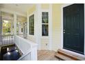 Exterior entryway with wooden porch, complemented by white trim, and black front door at 1717 Rivertowne Country Club Dr, Mount Pleasant, SC 29466
