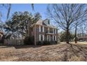Two-story brick home featuring a chimney, balcony, and mature trees on a neatly kept lawn at 24 N Basilica Ave, Hanahan, SC 29410