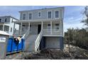 Two-story gray home with a white porch, garage, and landscaped yard at 3107 S Shore Dr, Charleston, SC 29407