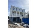 Two-story gray home with a white porch and a garage on elevated beams at 3107 S Shore Dr, Charleston, SC 29407