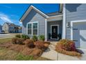 Charming front entrance featuring a decorated door, manicured landscaping and inviting entryway at 317 Catawba Branch Way, Moncks Corner, SC 29461