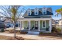Charming home with inviting front porch, dormer windows and lush landscaping at 411 Watergrass Way, Summerville, SC 29485