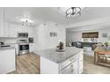 Bright kitchen with stainless steel appliances, a white island with granite countertops, and wood-look floors at 415 Parkdale Dr # 8A, Charleston, SC 29414