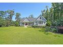 Charming gray home with a manicured lawn and inviting front porch, perfect for relaxing and enjoying the outdoors at 4162 Ten Shillings Way, Hollywood, SC 29470