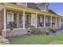 Inviting front porch with brick columns, rocking chairs, and well-manicured landscaping at 522 W Butternut Rd, Summerville, SC 29483