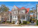 Charming two-story home featuring a cozy front porch, red roof, and well-maintained landscaping at 6 Halsey St, Charleston, SC 29401