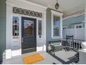 Inviting front porch with classic details, featuring a black front door and bench seating at 6 Halsey St, Charleston, SC 29401