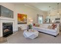 Cozy living room with a fireplace, modern furniture, and views into the kitchen at 107 Crosscut Ln, Summerville, SC 29486
