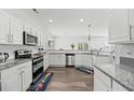 Modern kitchen with stainless steel appliances, white cabinetry, and granite countertops at 315 Sabal Palmetto Ct, Moncks Corner, SC 29461
