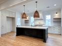 A well-appointed kitchen features a large island with a marble countertop and stylish pendant lighting at 3897 Summerton St, Mount Pleasant, SC 29466