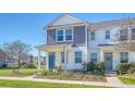 Charming two-story townhome with a well-kept lawn, inviting porch, and a vibrant blue door at 3941 Four Poles Park Dr, North Charleston, SC 29405