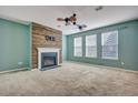Comfortable living room with a fireplace, wood accent wall, ceiling fans, and lots of windows at 429 Cherrybark Oak St, Summerville, SC 29486