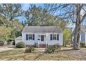 Charming single-story home with white siding, blue shutters and a detached garage at 4816 Chesterfield Rd, North Charleston, SC 29405