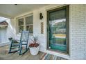Cozy front porch with rocking chair and potted plants on a quaint brick home at 5332 Parkside Dr, North Charleston, SC 29405