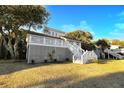 Charming white beach house on an elevated lot, surrounded by mature trees at 707 Palmetto Blvd, Edisto Island, SC 29438
