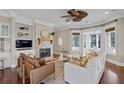 Cozy living room featuring built-in shelves, a stone fireplace, and a ceiling fan at 720 Island Park Dr # 104, Charleston, SC 29492